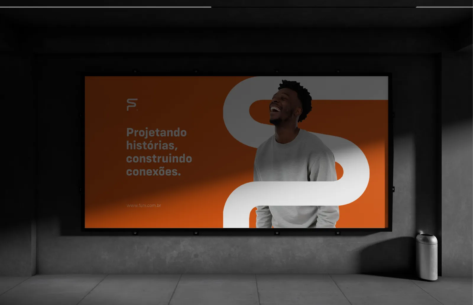 Painel em uma parede de concreto com a frase Projetando histórias, construindo conexões